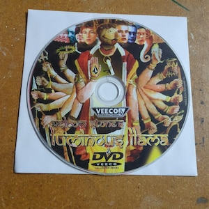 May include: A DVD disc with a colorful graphic featuring multiple figures and the text "Volcom Stone's Luminous Ilama." The disc is in a white paper sleeve. The DVD is part of the Veeco Collector Series.