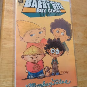 May include: A comic book titled "The Adventures of Barry Ween Boy Genius" with cartoon illustrations of four boys and a monkey. The cover is orange with blue and green text. The comic is in a protective plastic sleeve.