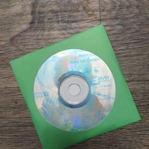 May include: A DVD disc labeled "Disc 1" inside a bright green paper sleeve. The DVD features the movie "Pay It Forward" and the names Kevin Spacey, Helen Hunt, and Haley Joel Osment.