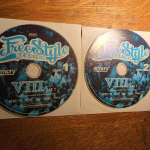 May include: Two circular DVDs labeled FreeStyle Session VIII Day 2, Disc 1 and Disc 2. The discs feature a blue and black graphic background with white text, including the Armory logo, NTSC format, and the website address www.freestylesession.com.