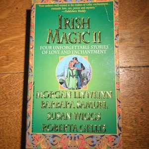 May include: A paperback book titled "Irish Magic II" with a green cover and gold lettering. The cover features a couple in a romantic embrace and the names of the authors: Morgan Llywelyn, Barbara Samuel, Susan Wiggs, and Roberta Gellis.
