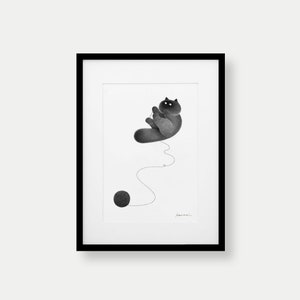 Puede incluir: Lámina artística enmarcada en blanco y negro que presenta una ilustración caprichosa de un gato jugando con una bola de lana. El gato, de color gris oscuro, está representado en una pose juguetona. El hilo está conectado a una bola gris oscura.