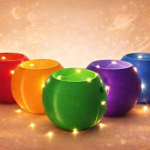 Può includere: Sei portacandele sferici colorati: rosso, arancione, verde, viola e blu. Ognuno ha una stringa di piccole luci bianche calde all'interno. Lo sfondo è di un colore caldo con un design celeste.