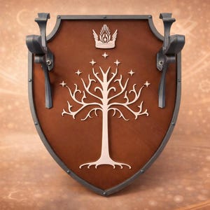 May include: A brown shield with a white tree and star design, featuring a crown at the top. The shield has grey metal accents and handles. A decorative item with a fantasy theme.