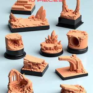 Puede incluir: Un conjunto de diez piezas de terreno en miniatura de color naranja, para juegos de mesa. El conjunto incluye varias estructuras como escaleras, formaciones rocosas y arcos, todas montadas sobre bases negras. El texto "Hero Terrain" y "Hero Base Bundle" es visible.
