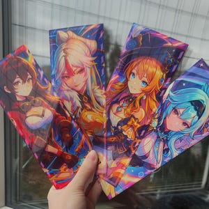 May include: Four colorful anime-style character prints are held up in front of a window. Each print features a different female character with detailed facial features, hair, and clothing. The prints have a vibrant color palette with a mix of reds, blues, and yellows.