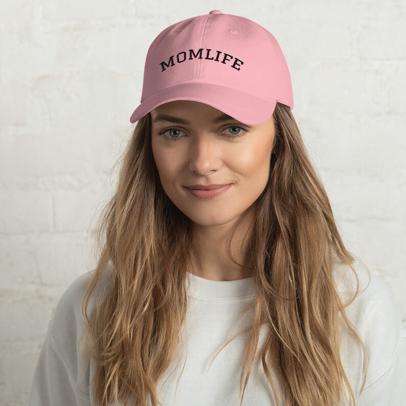 May include: A pink baseball cap with the text "MOMLIFE" embroidered in black on the front.