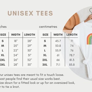 May include: Unisex t-shirt size chart in inches and centimetres. The chart shows the width and length of the shirt in each size, from S to 3XL. The chart is on a white background with a brown and white background behind it.