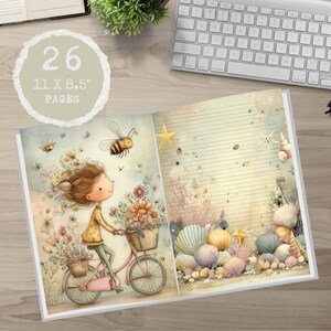 May include: Open journal with 26 pages, measuring 28 x 21.6 cm. The left page shows a girl on a pink bicycle with flower baskets, surrounded by bees. The right page has a beach theme with seashells and starfish.