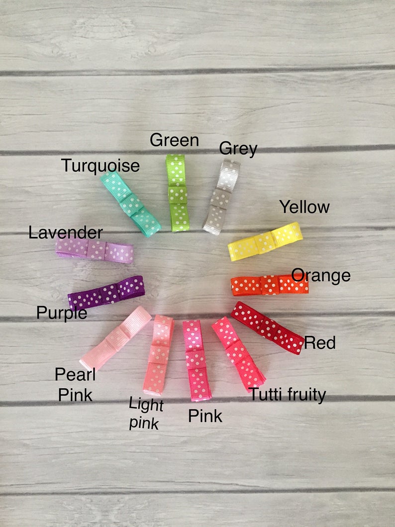 Op de afbeelding: Een set van 12 haarbandjes in verschillende kleuren met witte stippen. De kleuren zijn turquoise, lavendel, paars, parelwit, lichtroze, roze, groen, grijs, geel, oranje, rood en tutti frutti.