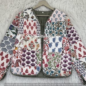 May include: A quilted jacket with a patchwork design. The jacket features various floral and geometric patterns in shades of red, blue, purple, and green on a white background. The interior lining is striped.