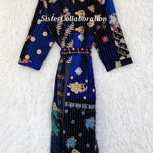 May include: A patchwork robe in navy, blue, and gold, with detailed embroidered floral and geometric patterns. The robe includes a matching belt and the text "Sister Collaboration".