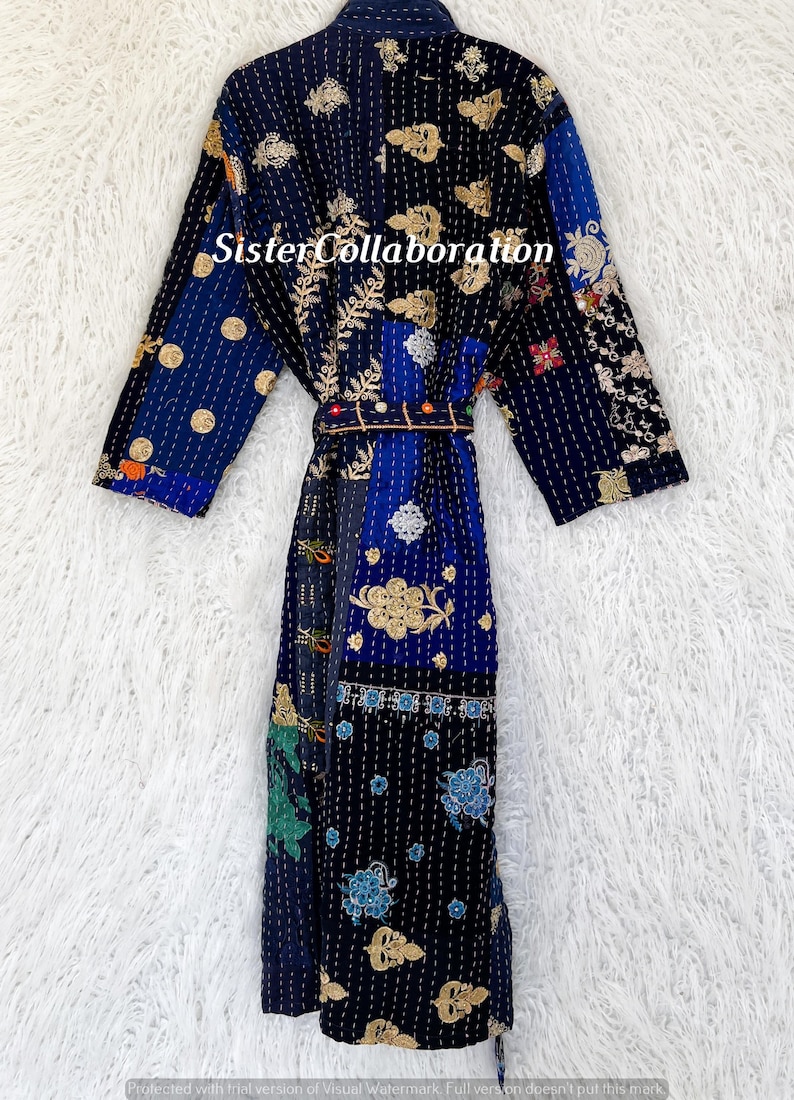 May include: A patchwork robe in navy, blue, and gold, with detailed embroidered floral and geometric patterns. The robe includes a matching belt and the text "Sister Collaboration".