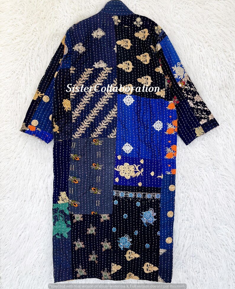 May include: A patchwork robe in shades of blue, black, and gold, with embroidered floral and geometric patterns. The robe has long sleeves and a collar. The text "Sister Collaboration" is visible on the front.