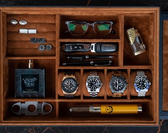 May include: A brown, velvet-lined organizer box filled with accessories. Items include eyeglasses, car keys, pens, watches, a lighter, cufflinks, a perfume bottle, a cigar cutter, and a yellow cigar case.