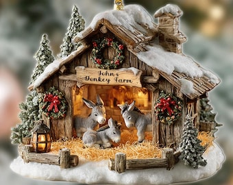 May include: A Christmas ornament featuring a miniature barn scene with three donkeys inside. The barn is made of wood and has a snowy roof. The text "John's Donkey Farm" is above the entrance. The ornament is decorated with small Christmas trees and wreaths.
