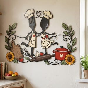 Può includere: Una decorazione da parete in metallo con una forchetta e un cucchiaio come personaggi chef, circondati da viticci, girasoli, un tagliere, una frusta, uno spicchio d'aglio, un pomodoro, un mattarello e una pentola rossa.