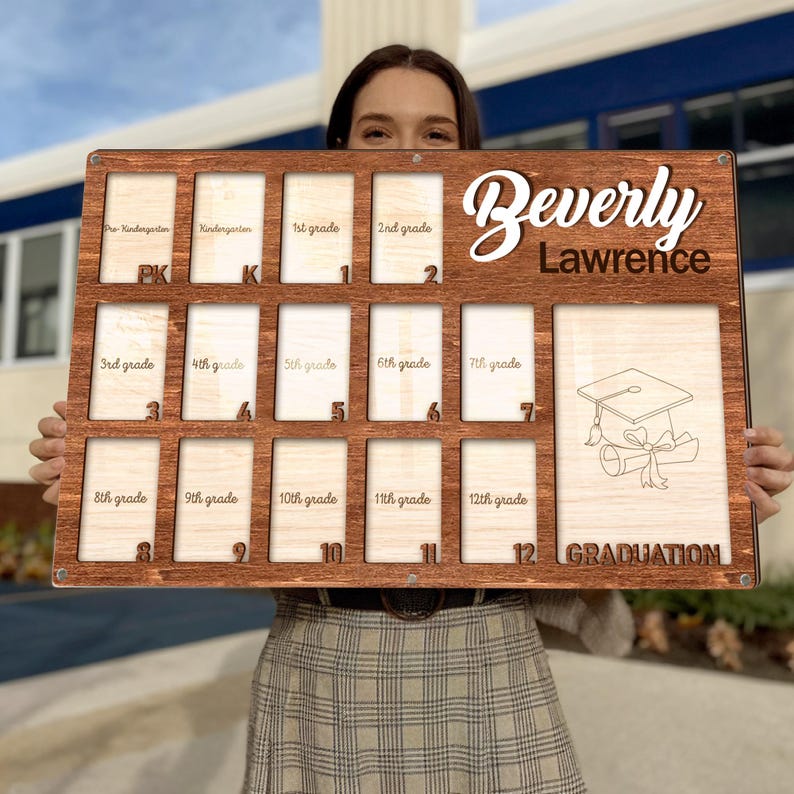 May include: A wooden graduation photo display board with spaces for photos from pre-kindergarten to 12th grade. The board is engraved with the name "Beverly Lawrence" and a graduation cap graphic. The word "GRADUATION" is also engraved.