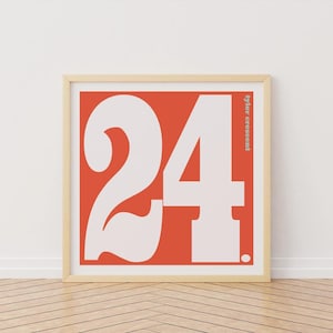Puede incluir: Un póster enmarcado con el número "24" en blanco sobre un fondo naranja vibrante. El diseño incluye el texto "tyler crescent" en vertical. El marco es de color madera clara. Diseño moderno.