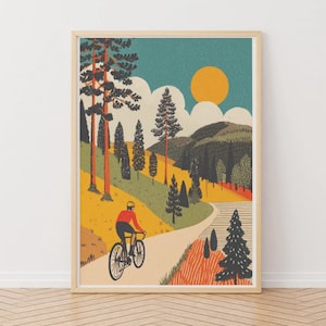 Könnte beinhalten: Ein gerahmter Kunstdruck zeigt einen Radfahrer auf einer kurvenreichen Straße durch eine farbenfrohe Landschaft. Die Illustration zeigt eine leuchtend gelbe Sonne, grüne Hügel und hohe Bäume mit orangefarbenen Stämmen. Der Radfahrer trägt ein rotes Hemd und einen gelben Helm.