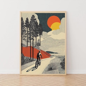 May include: Framed art print showing a cyclist on a winding path through a forest. The artwork features a stylized landscape with a red and orange sunset, tall trees, and a textured aesthetic.