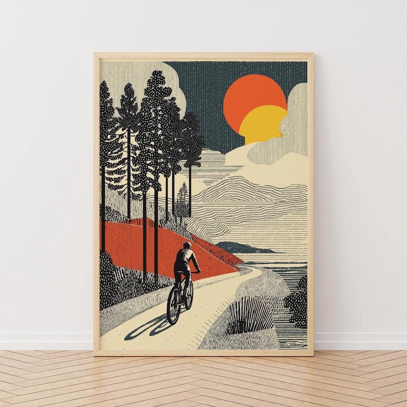 May include: Framed art print depicting a cyclist on a winding path through a forest. The artwork features a stylized landscape with a red and orange sunset, tall trees, and a textured aesthetic.