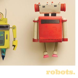 May include: Two colorful robot figures against a cream background. One robot is yellow with a blue and green triangle. The other is red with white and red cylindrical accents. The word "robots" is in yellow text at the bottom.