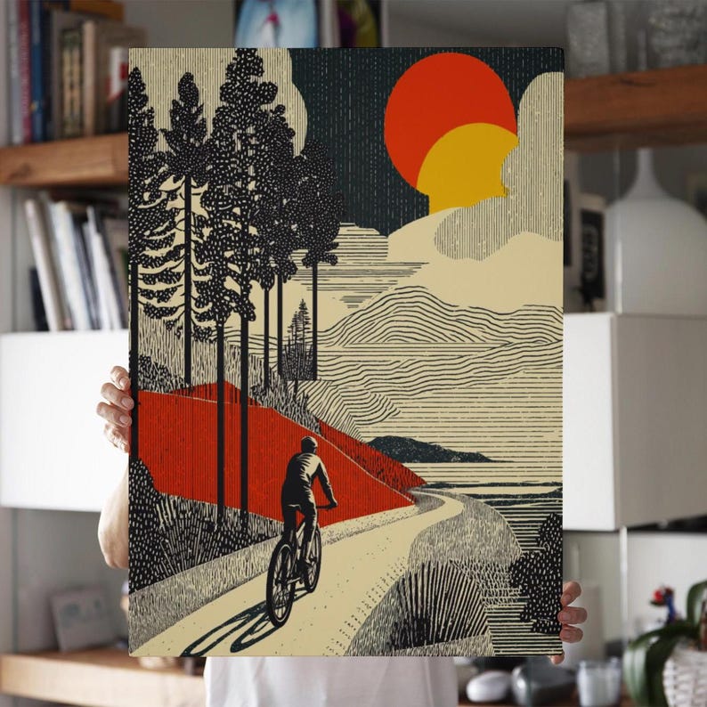 May include: A landscape art print featuring a cyclist on a winding road. The artwork uses a palette of black, red, and beige, with a stylized sun and trees. The print evokes a sense of adventure and outdoor activity.