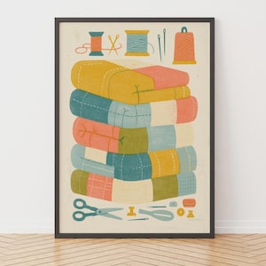Op de afbeelding: Een ingelijste kunstdruk met een stapel kleurrijke, doorgestikte dekens in tinten geel, blauwgroen, koraal en crème. Boven en onder de stapel staan illustraties van naaibenodigdheden zoals garenklosjes, naalden en een schaar.