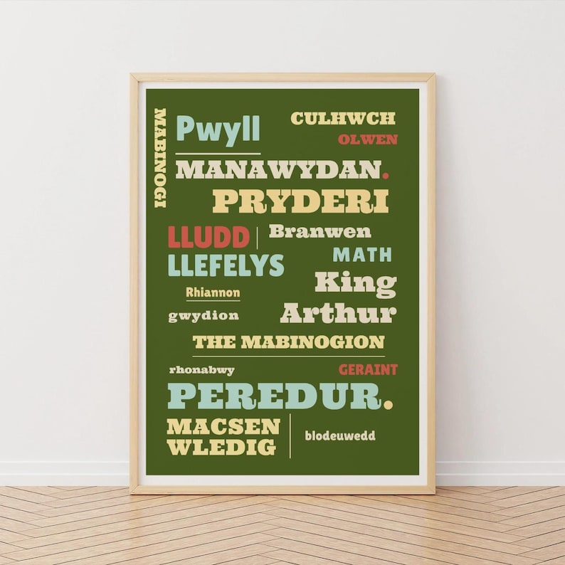 May include: A framed print with a green background and text in various colors. The text includes names like "Pwyll," "Manawydan," and "Peredur." The words "The Mabinogion" are also visible. The print is in a light-colored wooden frame.