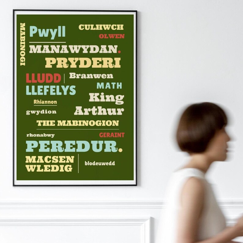 May include: A framed poster with text in various fonts and colors. The poster's background is dark green, with text in white, yellow, and red. The text includes names and phrases, such as "Pwyll," "King Arthur," and "The Mabinogion."
