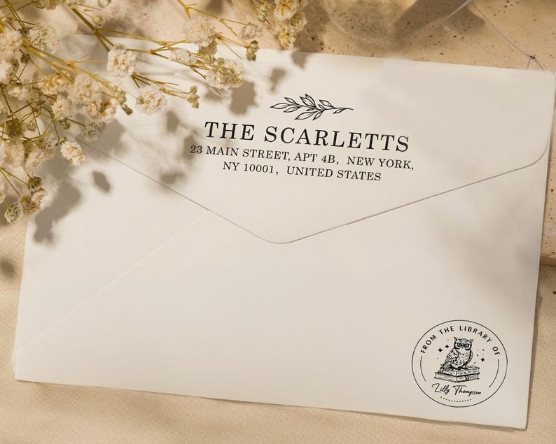 May include: Cream-colored envelope with the address "THE SCARLETTS" and address details printed in black. A circular stamp at the bottom reads "FROM THE LIBRARY OF" with an owl illustration and the name "Zilly Thompson".