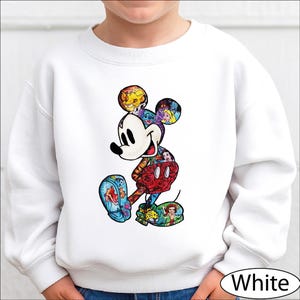 A white sweatshirt with a colorful, cartoon-style illustration of Mickey Mouse printed on it.