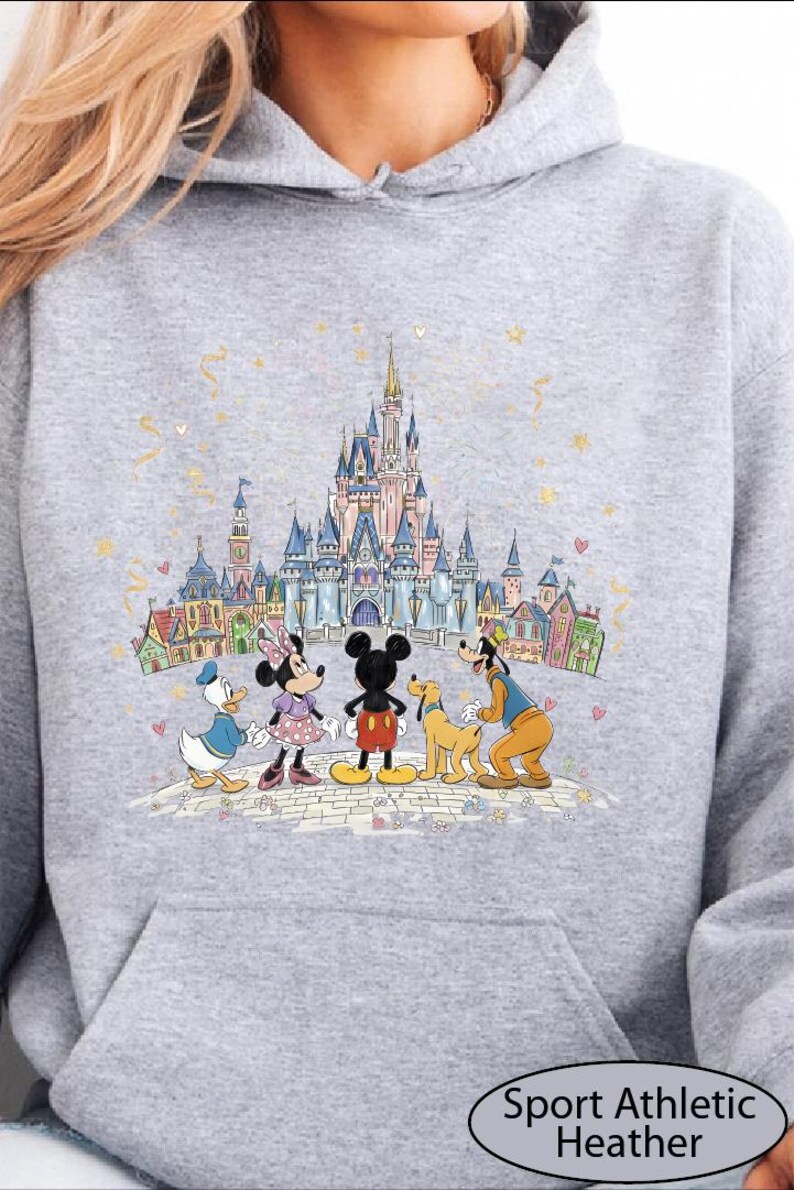 A gray hoodie with a graphic design featuring Disney characters Mickey Mouse, Minnie Mouse, Goofy, and Donald Duck standing in front of a castle.