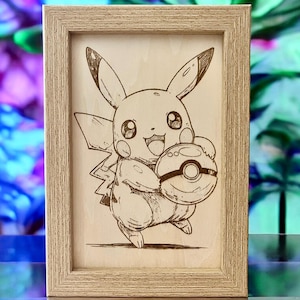 Może przedstawiać: Oprawiona grafika wypalana w drewnie przedstawiająca Pikachu, popularną postać z serii Pokémon. Grafika przedstawia Pikachu trzymającego Poké Ball, z szczegółowymi konturami i cieniowaniem. Rama jest w jasnobrązowym kolorze, dodając rustykalnego charakteru.