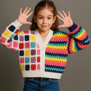 May include: A colorful crochet cardigan with a V-neck and button closure. The left side features square blocks of various colors, while the right sleeve and front panel display rainbow stripes. The sleeves have navy blue cuffs. The cardigan is worn by a person.