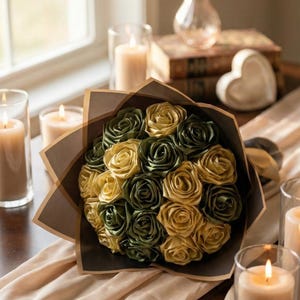 Handmade forever flower bouquet featuring olive green and golden yellow satin ribbon roses wrapped in elegant translucent brown paper. A luxury long lasting floral gift designed for weddings, anniversaries, Mother’s Day, and romantic occasions. Displayed in a modern neutral interior setting with jewelry box and soft natural light. A timeless artificial rose bouquet that never fades and serves as a keepsake floral arrangement.