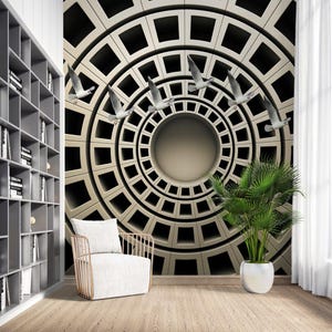 May include: A modern interior featuring a geometric wall mural with a circular design and flying birds. A white armchair with a gold frame sits in front of the mural. A bookshelf and a potted plant are also visible.