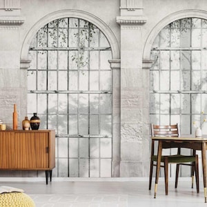 May include: A room with a large, arched window design on the wall. The wall has a textured, stone-like appearance. A wooden cabinet, table, and chair are in the room. The window design features a grid pattern with a view of foliage.