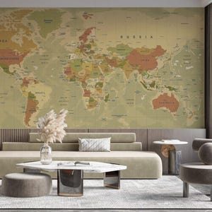 Puede incluir: Un gran mural de mapa del mundo de estilo vintage en tonos apagados de verde, marrón y naranja domina la pared. El mapa está detallado con nombres y fronteras de países. La habitación cuenta con muebles modernos, incluyendo un sofá, una mesa de centro y una silla auxiliar.