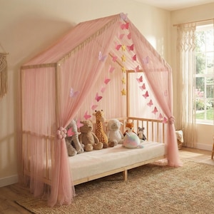 May include: A light wood-framed bed with a pink canopy and sheer curtains. The canopy is decorated with paper butterflies and stars. Several stuffed animals are arranged on the bed, including a giraffe, bear, and sheep.
