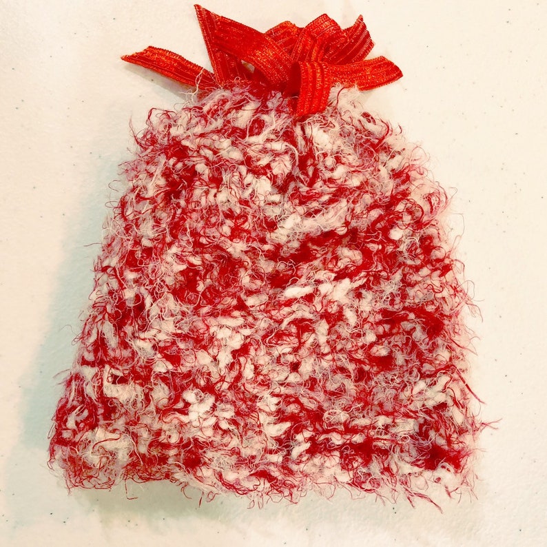 Peut inclure: Un chapeau rouge et blanc en fourrure avec un n&oelig;ud rouge sur le dessus.