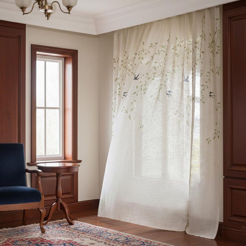 May include: A light-coloured curtain with a botanical design. The curtain has a pattern of green leaves and small blue birds. The curtain is hanging in front of a window, and the light is shining through it.