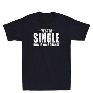 May include: Black t-shirt with the white text "YES I'M SINGLE NOW IS YOUR CHANCE". The text has a distressed, vintage look. The shirt is a classic crew neck style.
