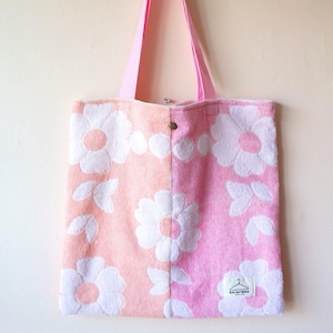 Può includere: Borsa tote rosa e pesca con motivo floreale bianco. La borsa ha un cinturino rosa e una chiusura a scatto. La borsa è realizzata in un materiale morbido e strutturato. L'etichetta recita "re-wired".