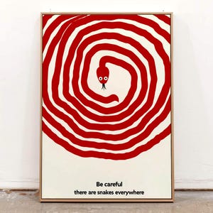 Peut inclure: Une affiche encadrée avec un motif en spirale rouge et blanc et une tête de serpent. Le texte en bas dit "Faites attention, il y a des serpents partout."