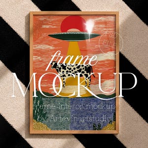 May include: Framed art print with a cow under a UFO against an orange sky. The artwork has a retro style with the words "frame MOCKUP" in white. The print is displayed on a striped rug.