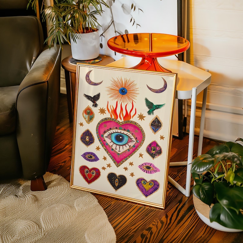 A vibrant mystical poster featuring a flaming heart with a central blue evil eye surrounded by celestial symbols, stars, moons, and birds. Embellished with jewel-like details and bright colors, this maximalist artwork blends folk art and spiritual symbolism, making it a bold bohemian wall decor piece.Mystical Eye Art, Spiritual Decor, Celestial Folk Print, Bohemian Wall Art, Protective Eye Print, Dopamine Decor, Maximalist Art, Sacred Heart Art, Colorful Mystical Decor, Eclectic Spiritual Print