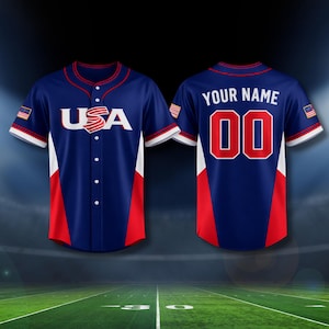 Puede incluir: Una camiseta de béisbol azul marino con detalles rojos y blancos. La parte delantera muestra "USA" en letras blancas. La parte trasera tiene "YOUR NAME" sobre el número "00" en rojo con un contorno blanco. Las mangas tienen una pequeña bandera americana.