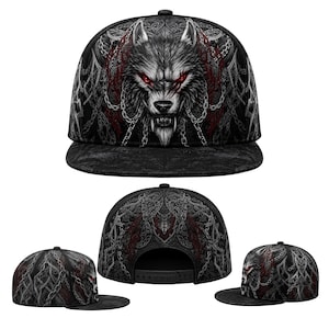 May include: A black snapback cap featuring a detailed graphic of a snarling wolf with glowing red eyes, surrounded by silver chains and intricate grey knotwork patterns. The design is printed across the front panels and the flat brim of the hat.